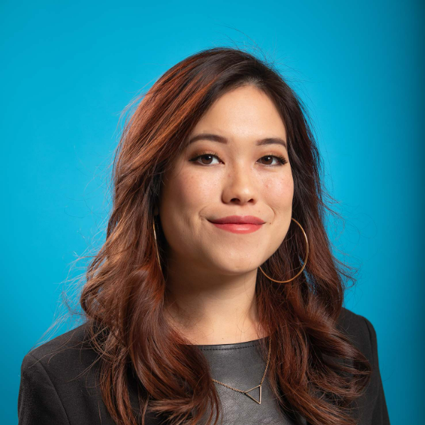 On blue blackground, portrait photo of Grace Chung smiling, wearing black.
